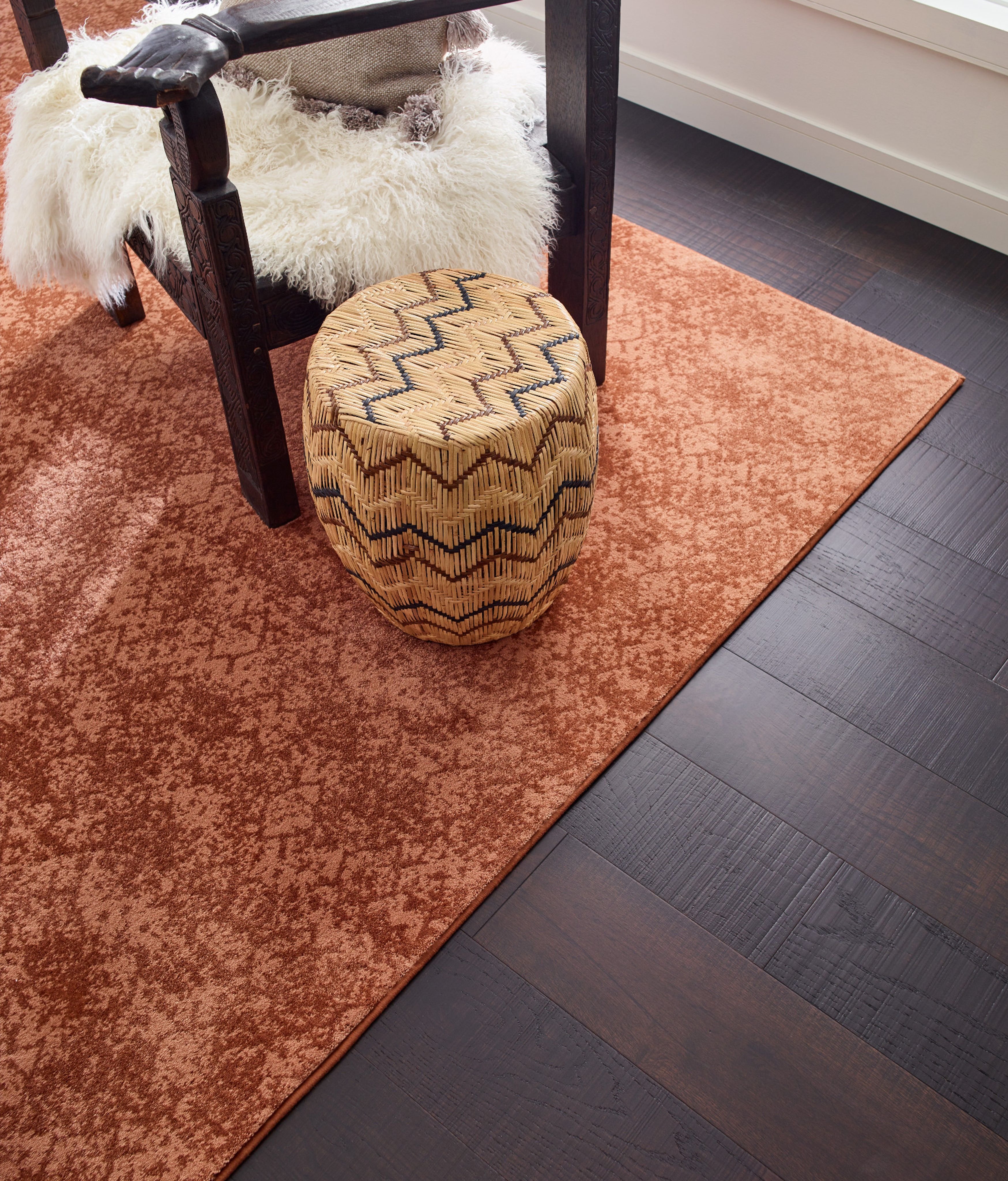 room with dark hardwood flooring and an orange patterned rug from Excel Carpet LTD in the Commack, NY area