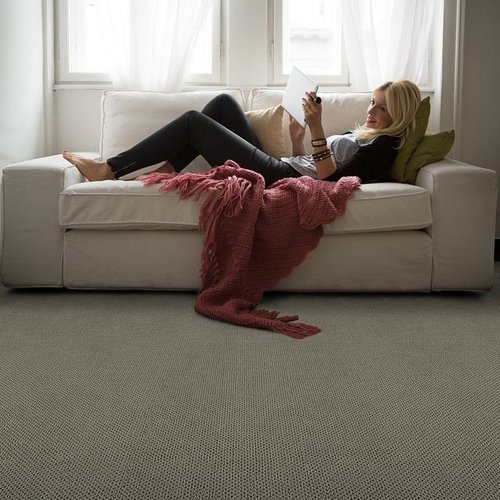 A woman is reading something from Excel Carpet LTD in Commack